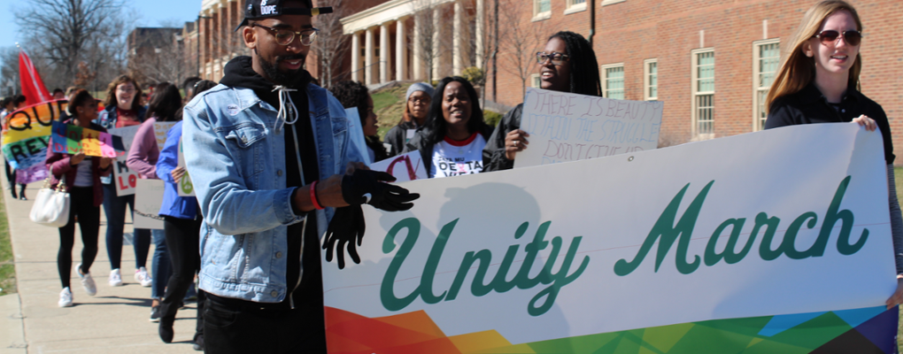 Two members of the Diversity Affairs Council leading Unity Day March while carrying Unity Day banner
