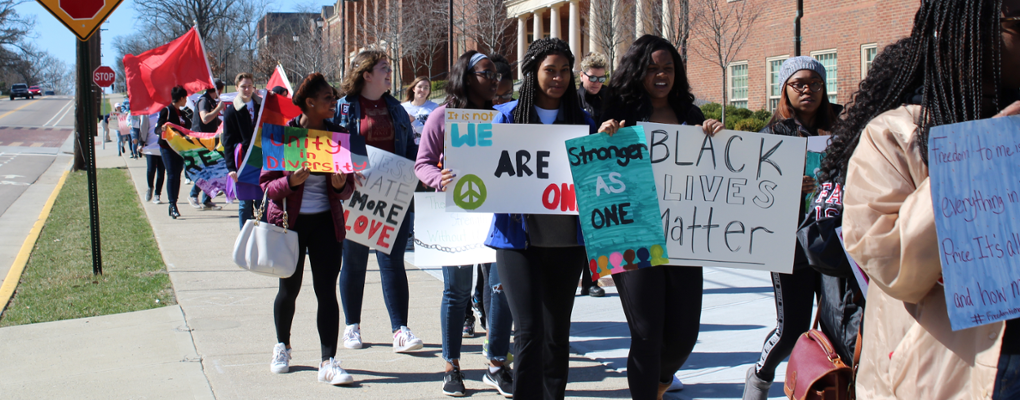 Students carrying signs during Unity Day March 2018 portraying social justice for different identities