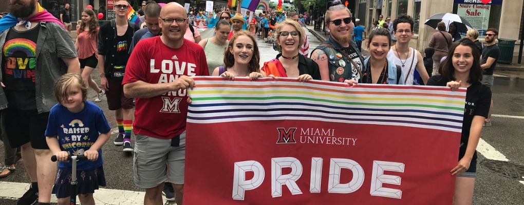 President Crawford holding a Miami University Pride banner at the Pride parade in Cincinnati