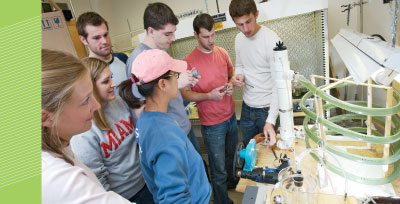 (From left) Emma Witte, Katy Kadlec, Sara Katz, Dan Krzmarzick, Joe Stevenot, Seth Buckwalter, and Bryan Glaenzer check the progress of the team’s photobioreactor, designed to produce hydrogen through the use of cyanobacteria.