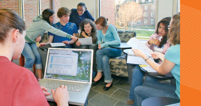(From left) Chelsie Goyings, Lauren Kepple, Nicholas Anderson, Sheryl Kavetza, assistant professor Annette Bollmann, Alison Simerlein, Maroui Lalvani, and Kari Noble discuss the team’s findings in the production of ethanol from switch grass.