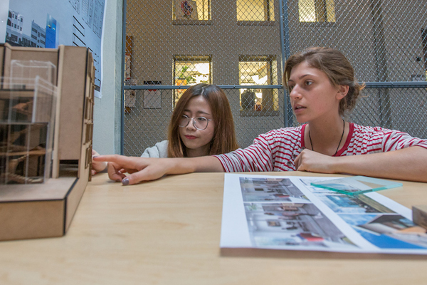 Two students review their work inside the cage gallery