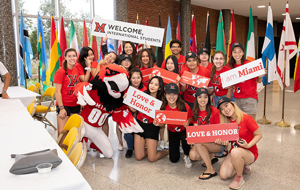 Group of student with various signs welcoming international students to Miami