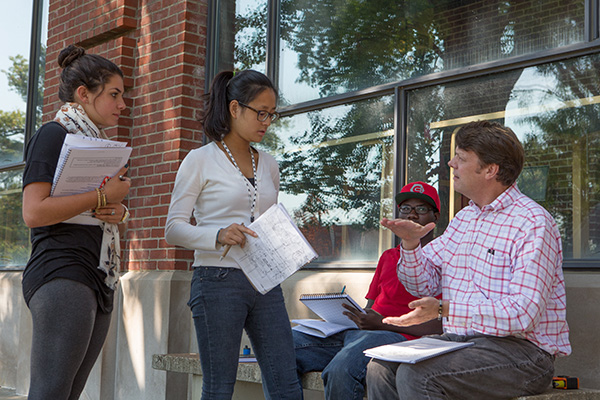  Two students working with faculty and community members in a local neighborhood