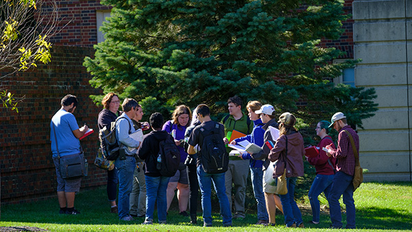  Botany class outside, gathered around a tree and doing an identification exercise.