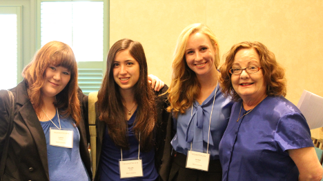 Kate Ronald posing with 3 students at conference.