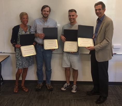 The faculty proudly hold their certificates upon graduating from the Fellows program
