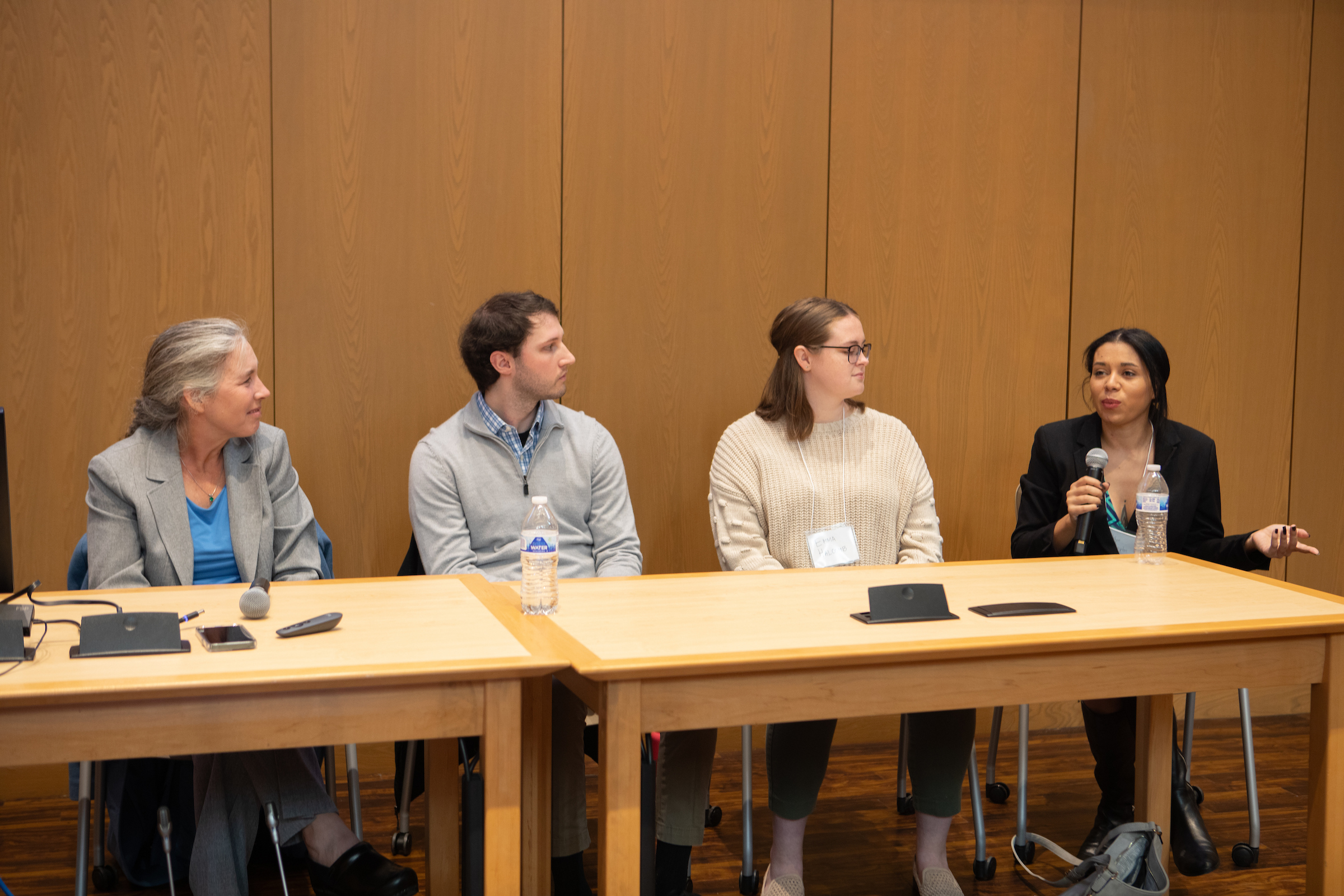 A panel discussion during the AI symposium that had a fulty member and three students address the attendees