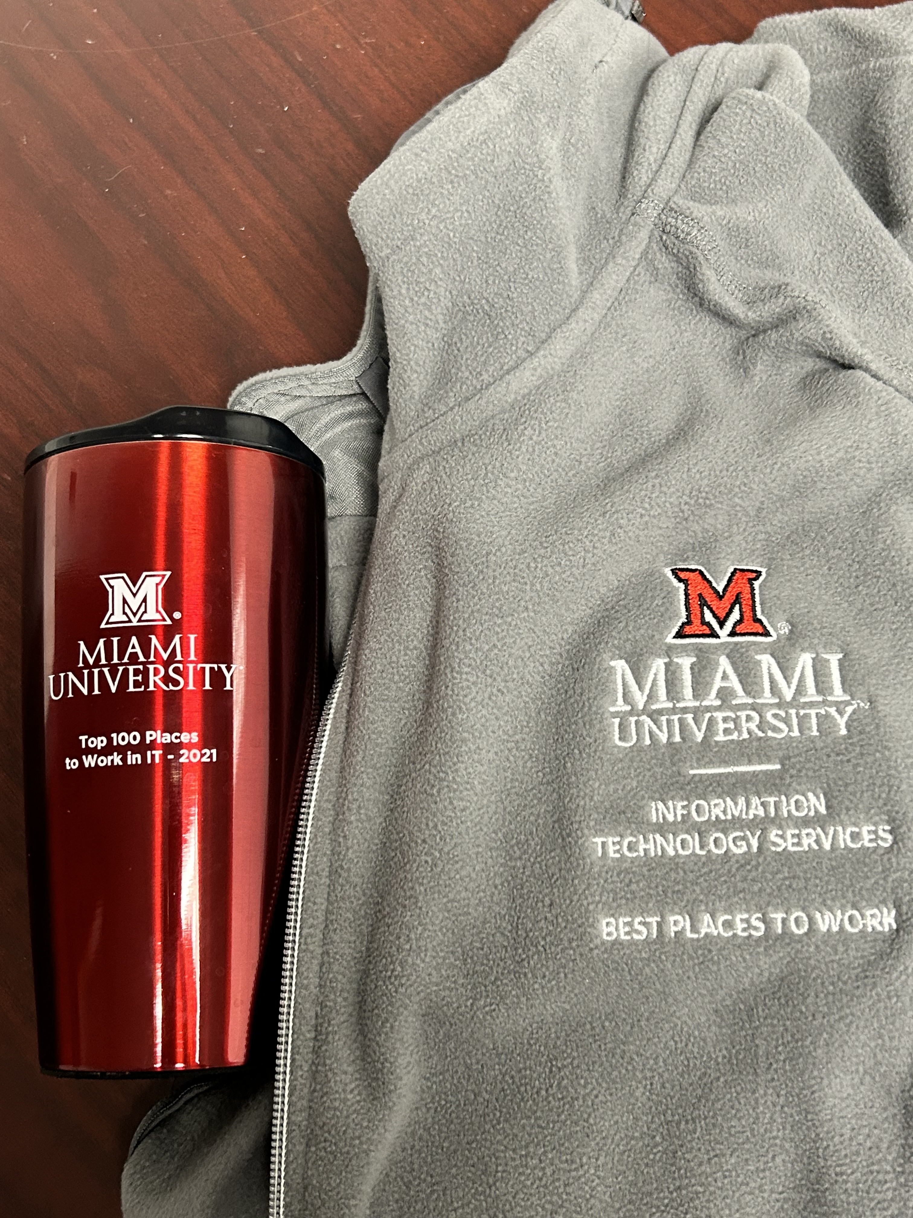 The mug and jacket that show the Best Places to Work in IT graphic