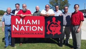 IT Services staff and Chief pose in front of Miami Nation sign