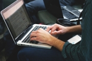 A person's hands poised above a laptop