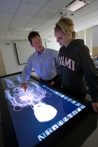Instructor pointing at virtual cadaver while working with a student