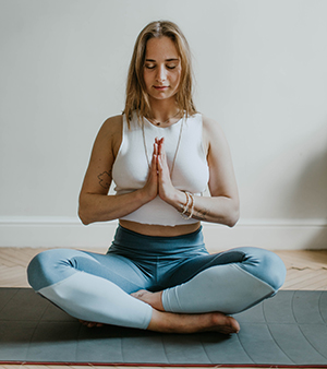 Young woman sitting in a yoga pose with eyes closed