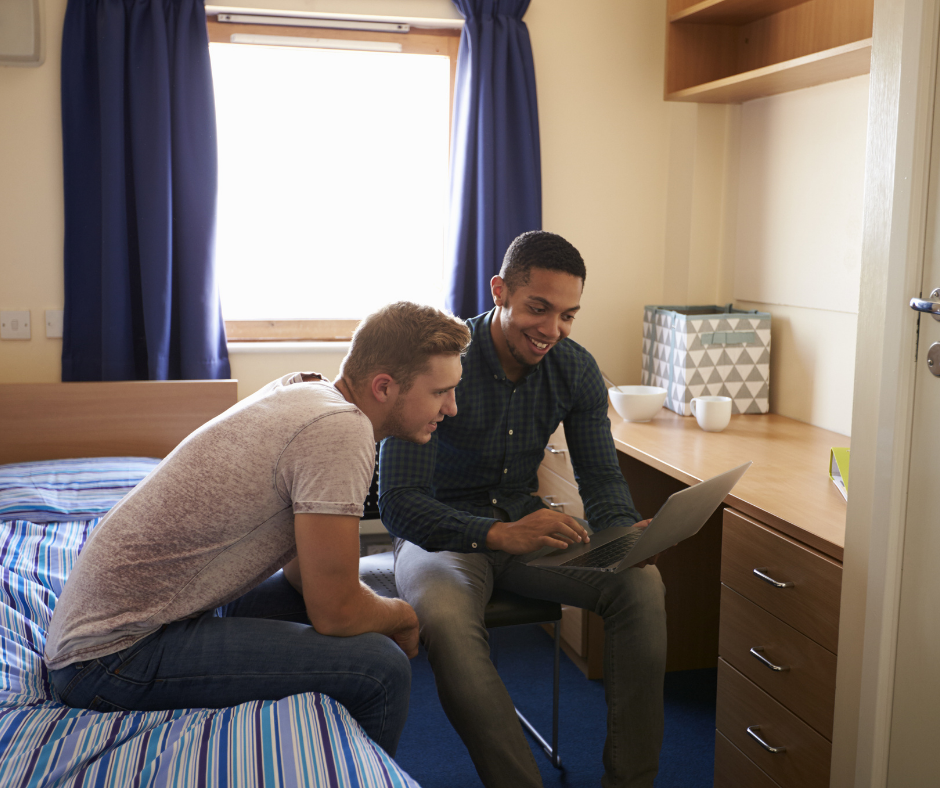 Two Male Students Watching TV on their laptop in a residence hall room