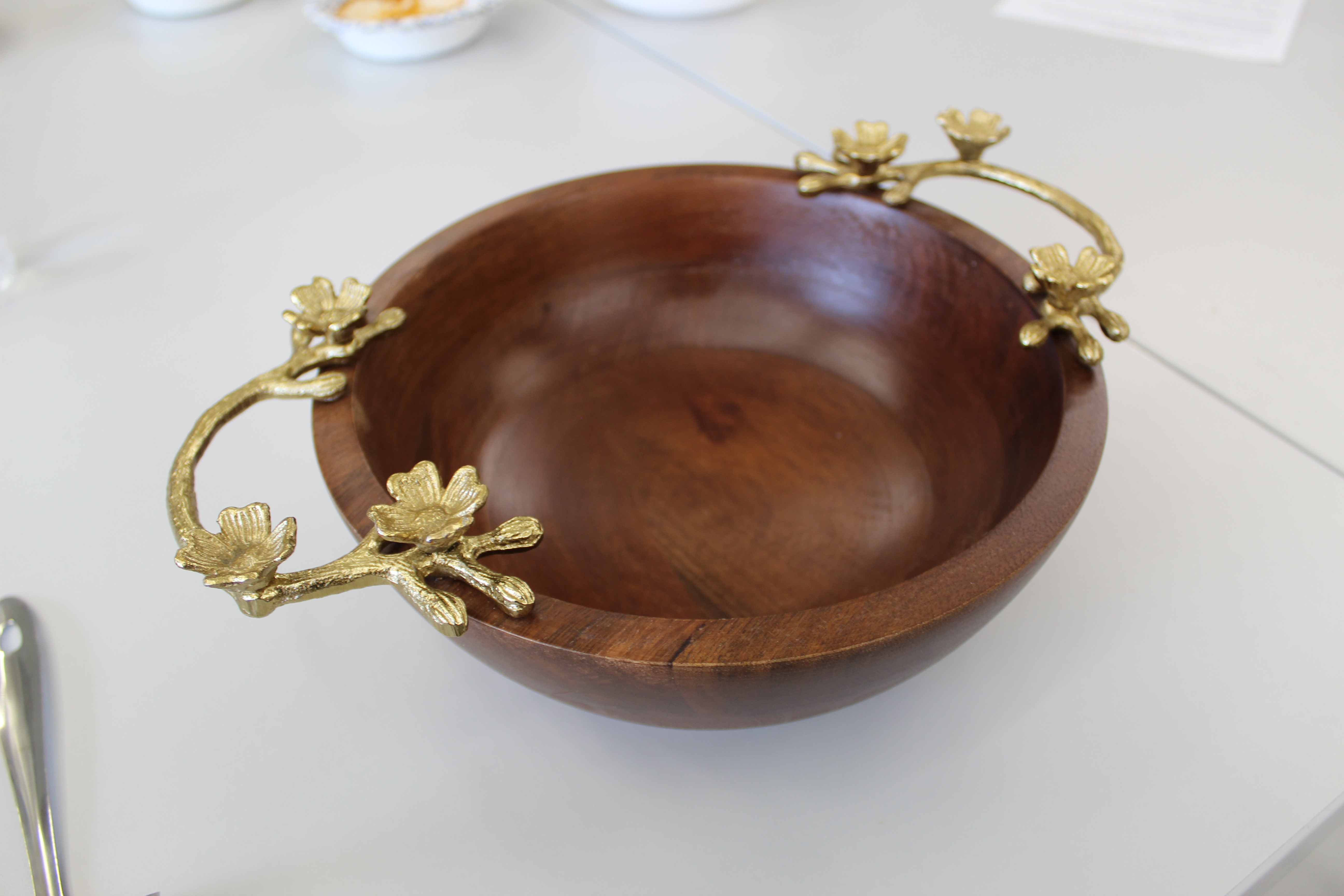 A wooden bowl with gaudy golden handles
