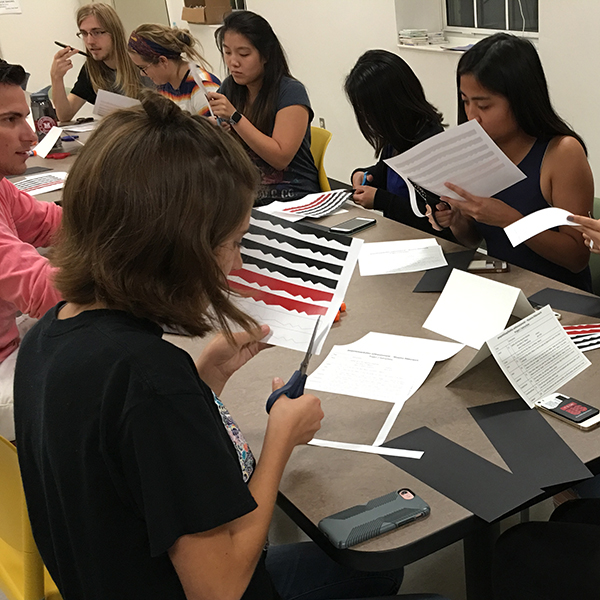 Students creating paper ribbonwork at residence hall event