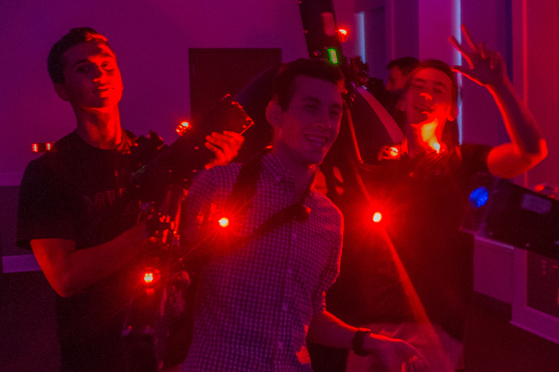 Students shoot red lasers from laser tag gear