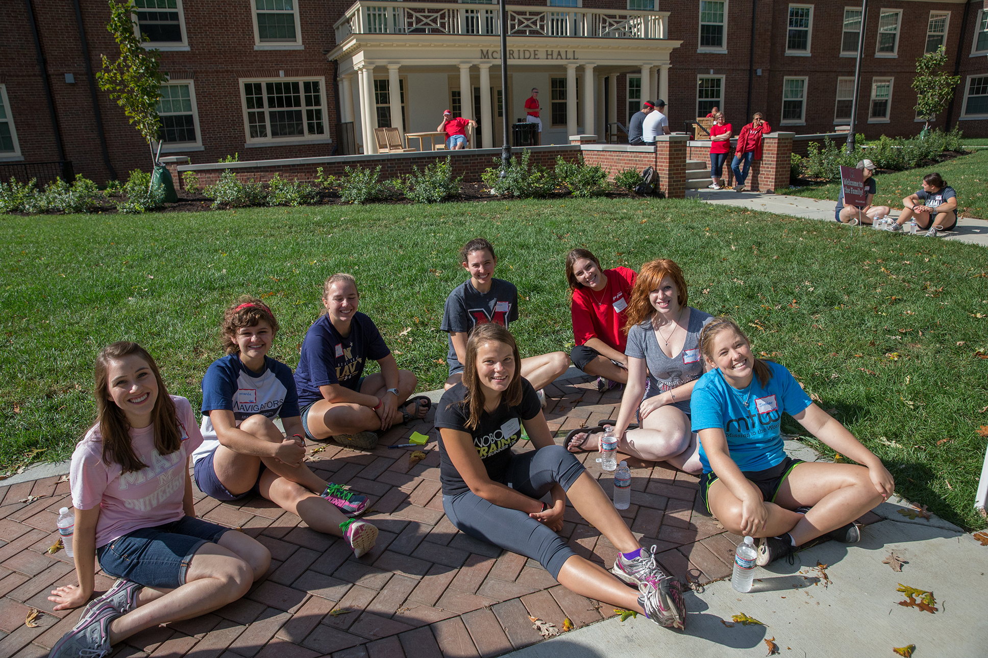 A group of student volunteers take a break, sitting on the ground