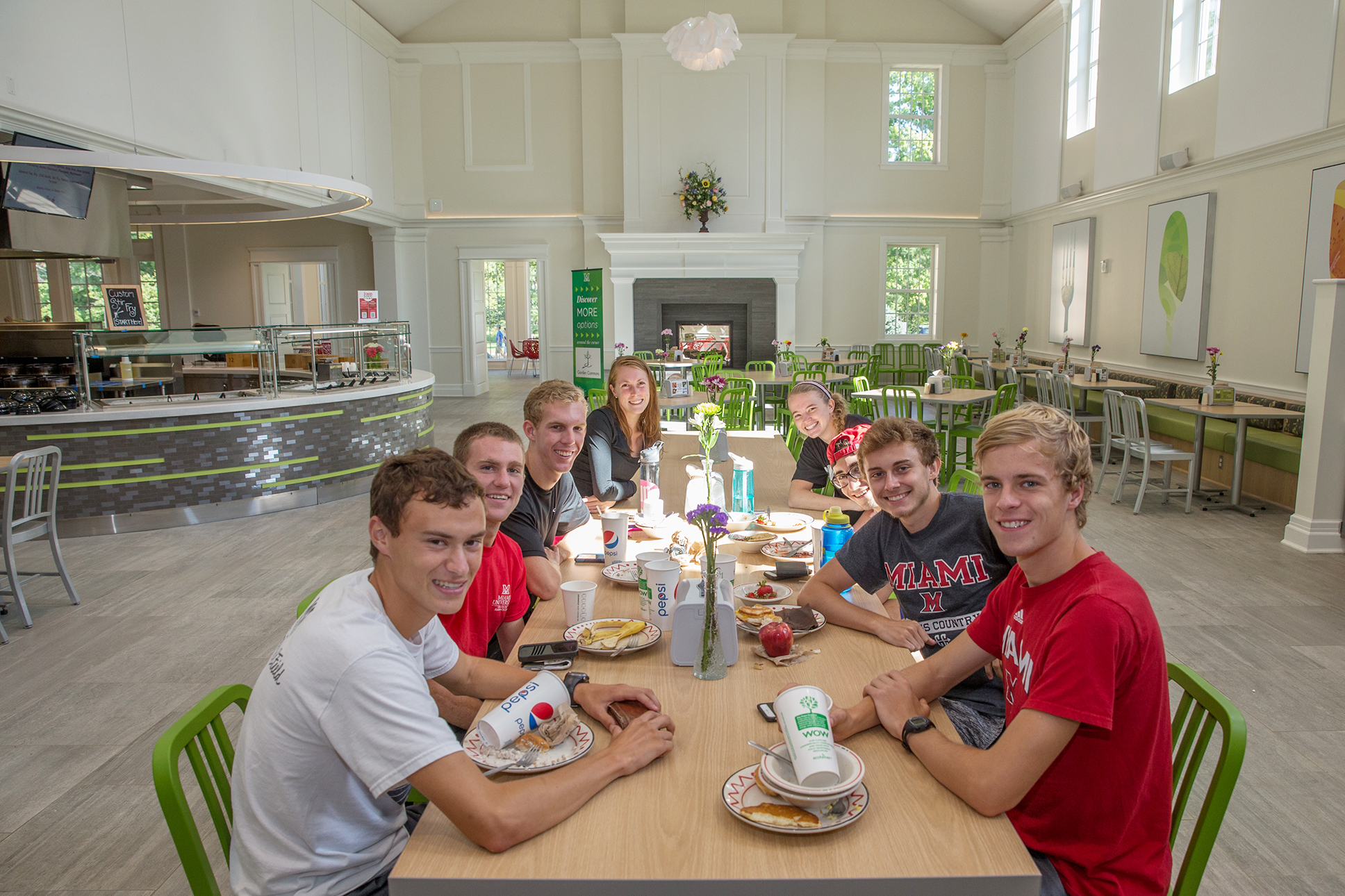 Students sit together at a wooden table at a new dining facility