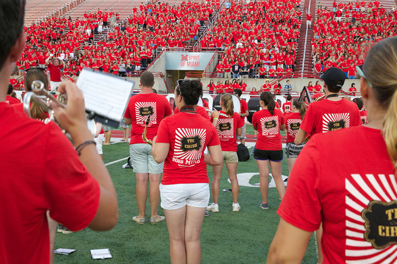 The marching band stands on the football field, playing a song for the first-year class