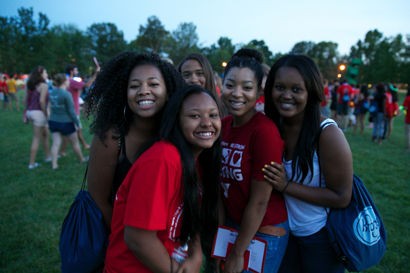 A group of students smile at dusk