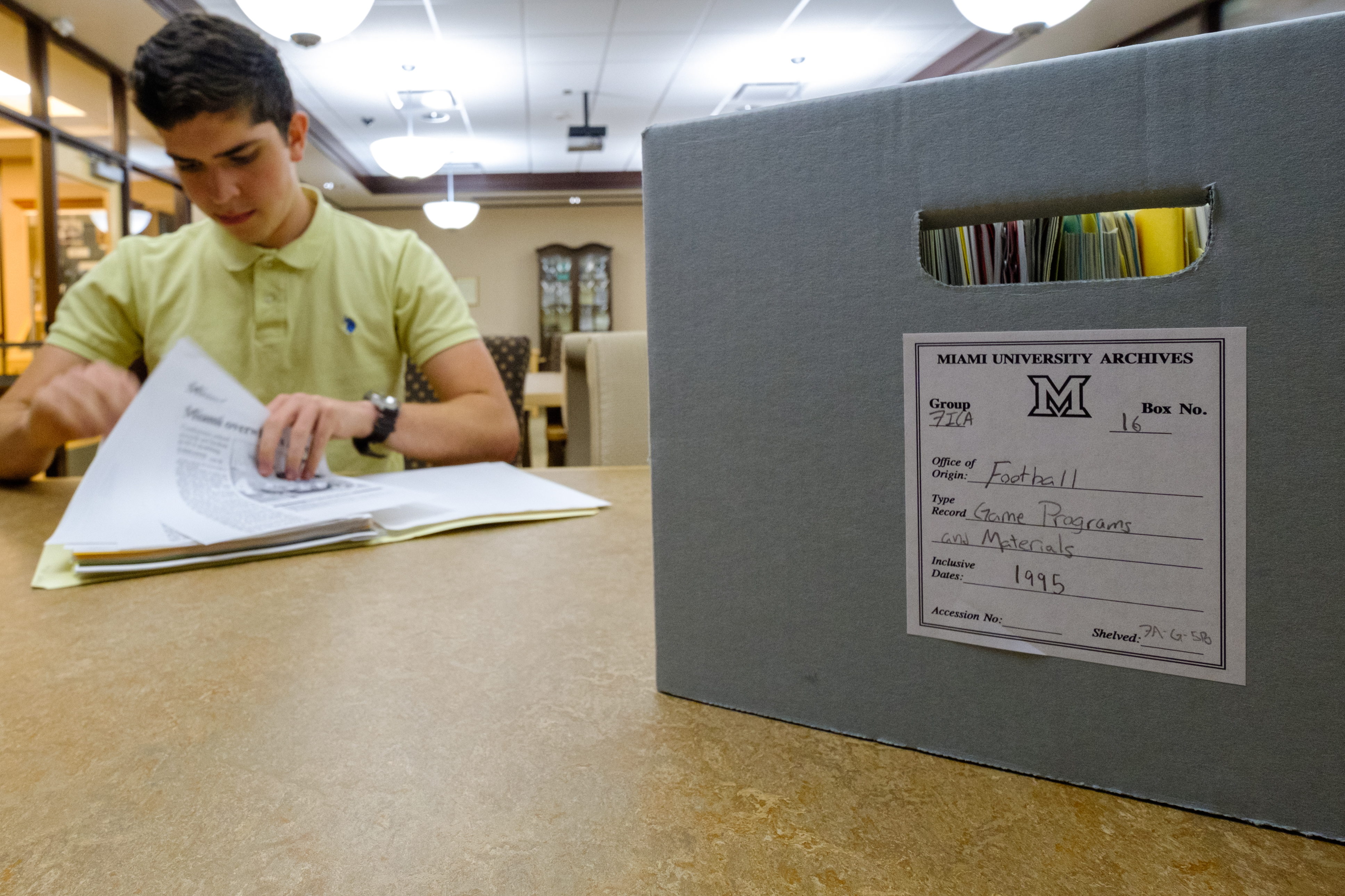Photo of student with box of archival material