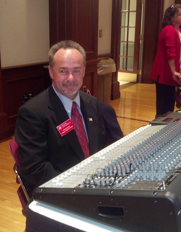 John Moore sits at his soundboard.