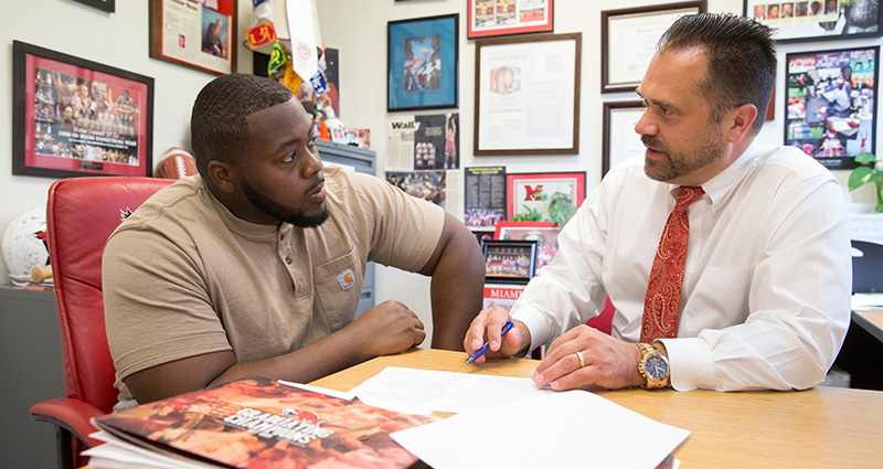 Defensive tackle Nate Trawick, a junior economics major and marketing minor, talks to Craig Bennett, assistant athletic director for academic support services. 
