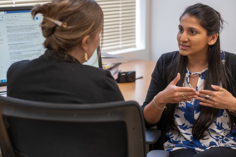 Akanksha Das talks with another person inside a Miami psychology lab.