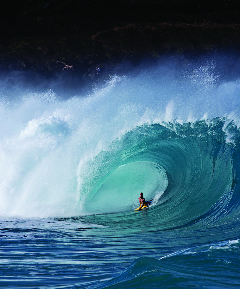 A curving wave over a surfer
