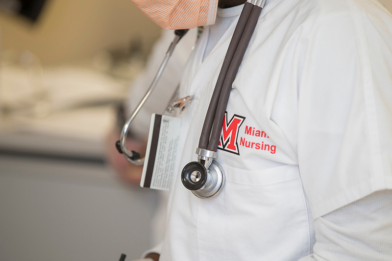 A midsection view of a Miami nursing student wearing scrubs and a stethoscope around their neck.