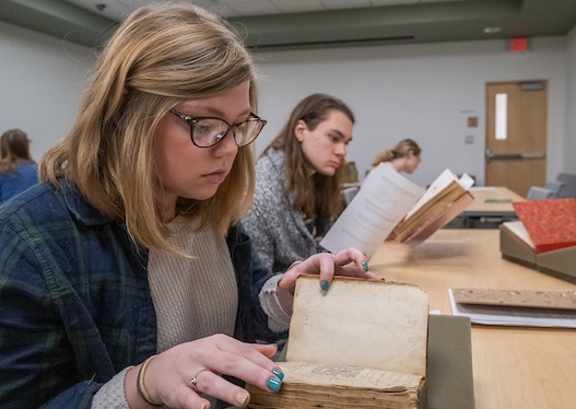 Student reviewing historical book