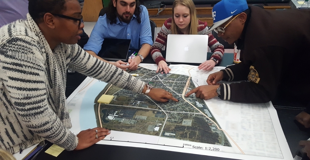 Miami students and Hamilton residents talk around a neighborhood map.