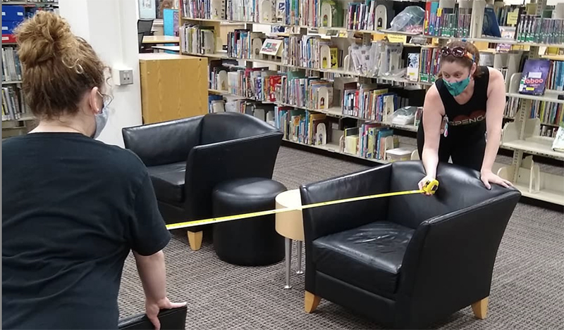 Workers Adjusting Library Chair Distances