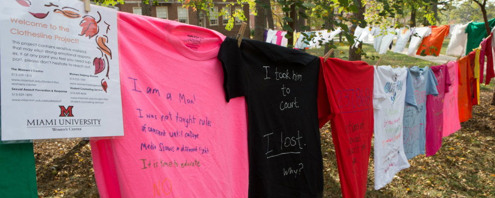 A line of colorful hand-lettered t-shirts comprise the Clothesline Project display, raising awareness of sexual assault on campus