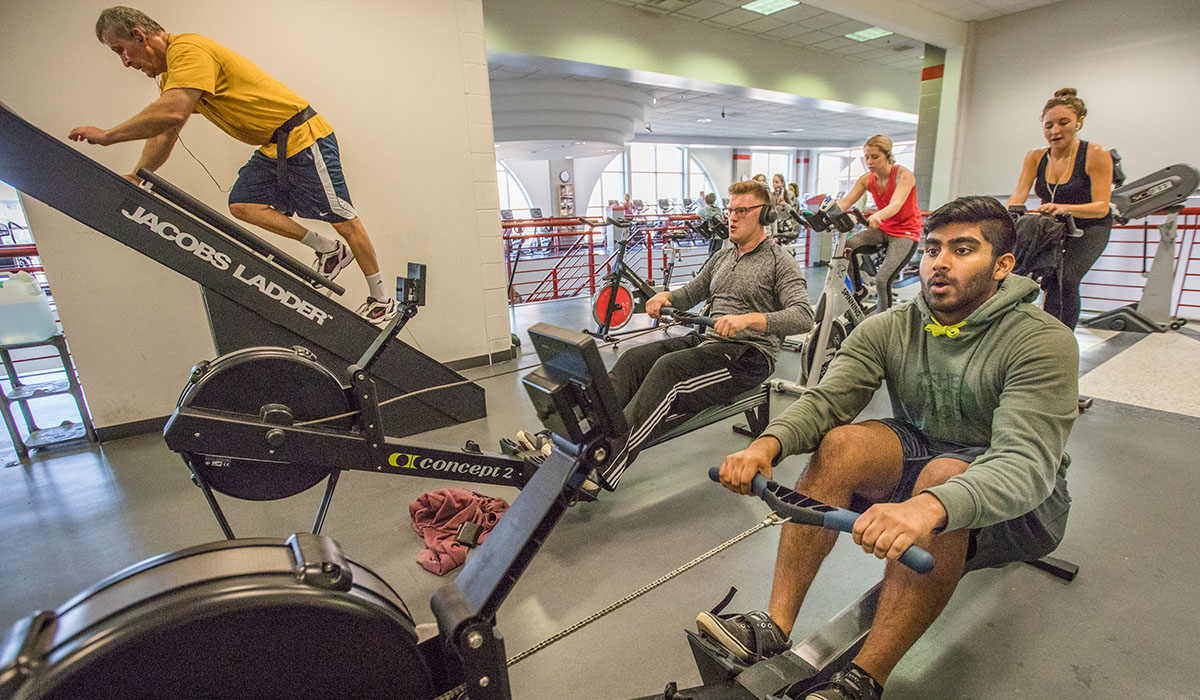 students and staff using various machines at the Rec