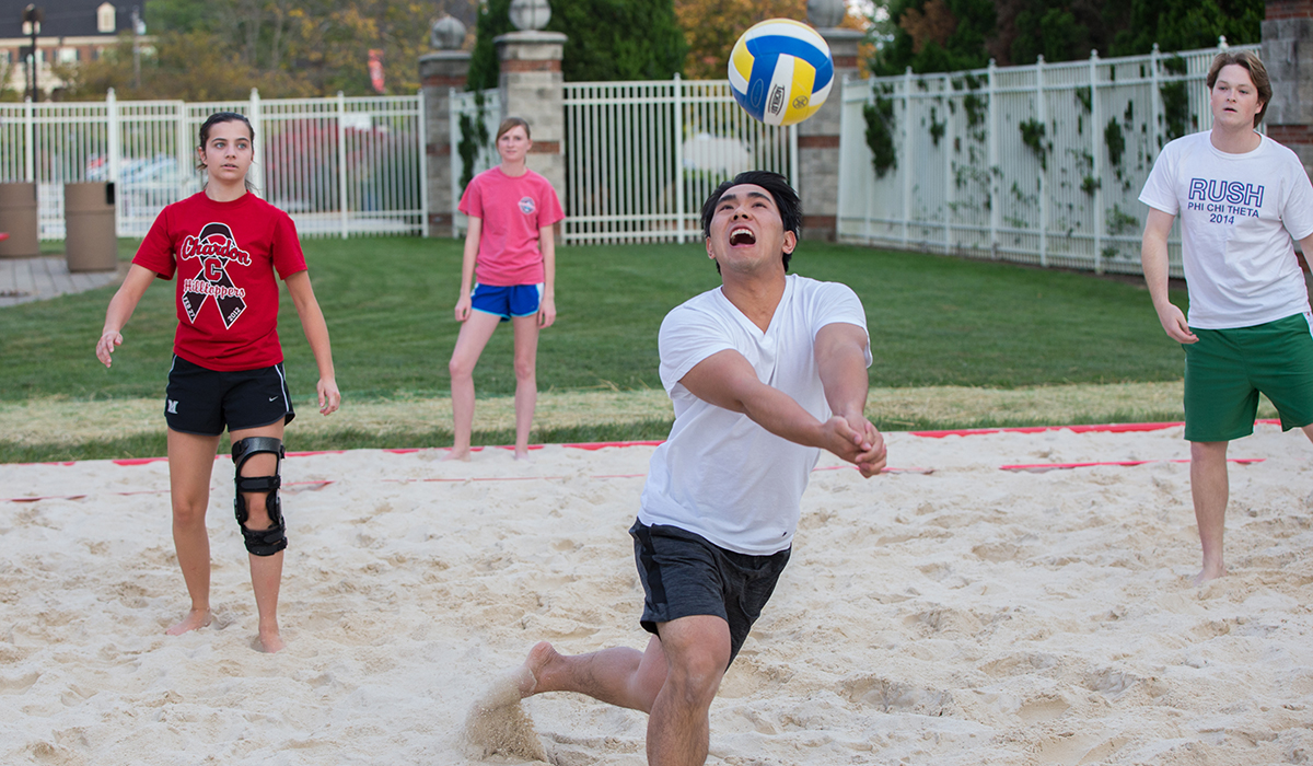students playing sand volleyball