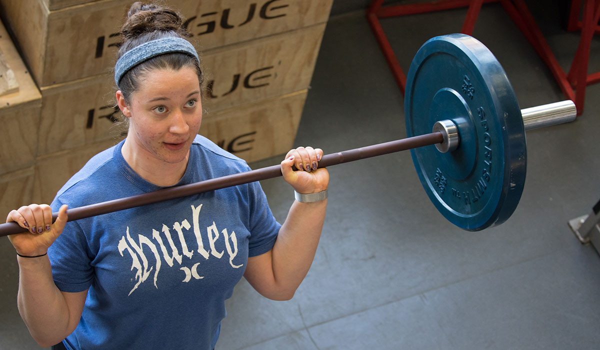 female student lifting a barbell