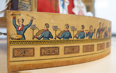 close up view of a historic toy theatre showing images of musicians