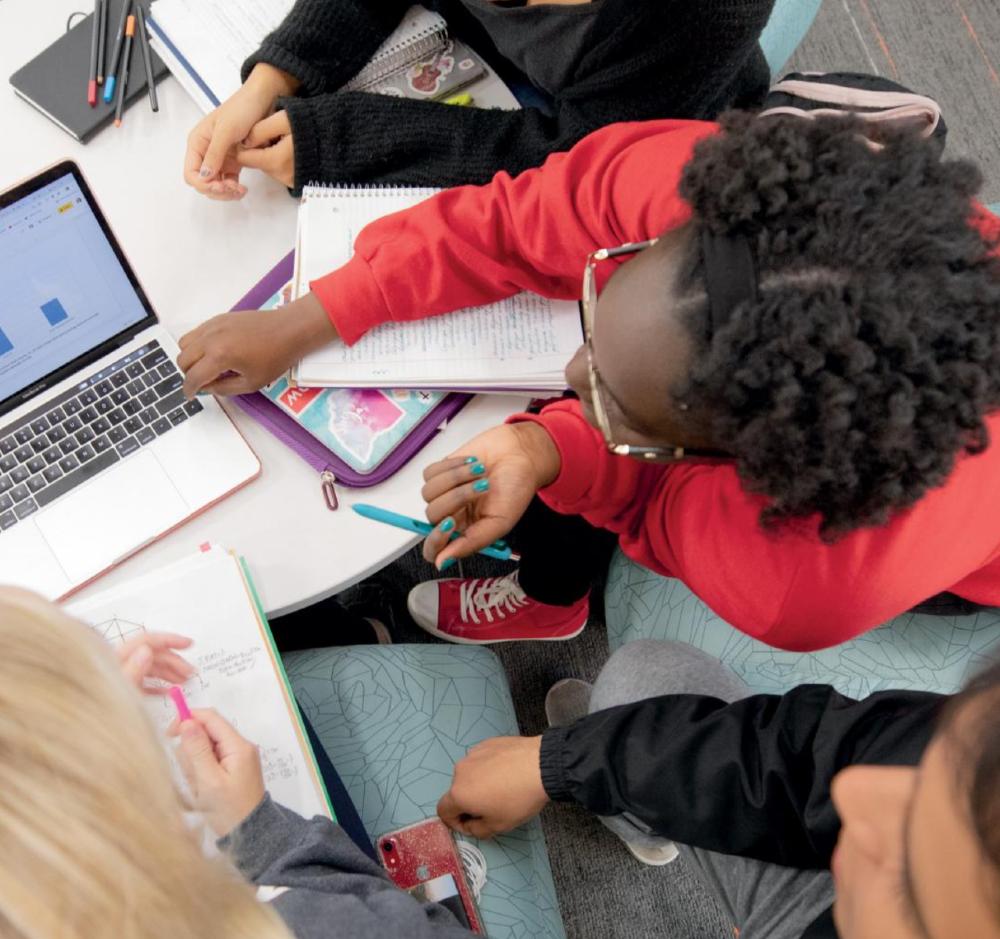 Students gathered around a laptop working together
