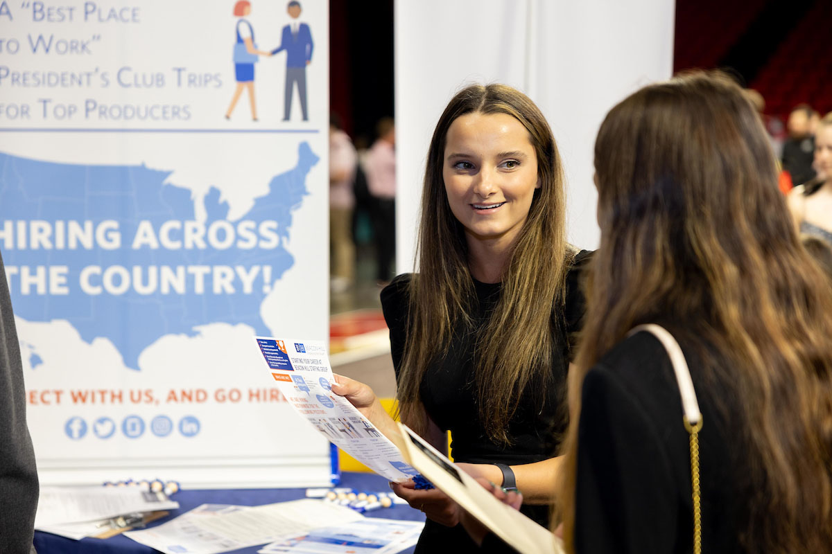 Two students in front of a poster at a Miami University career fair