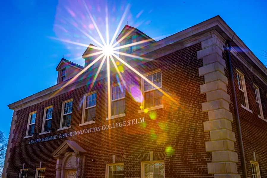college at elm building with sunburst shining through from roof