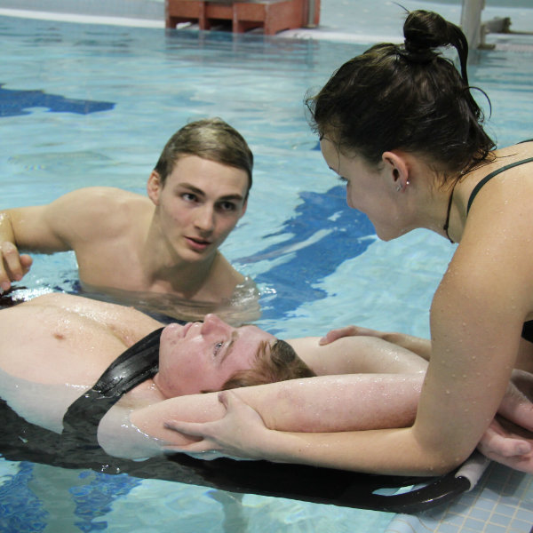 Students practicing backboard rescue in the pool