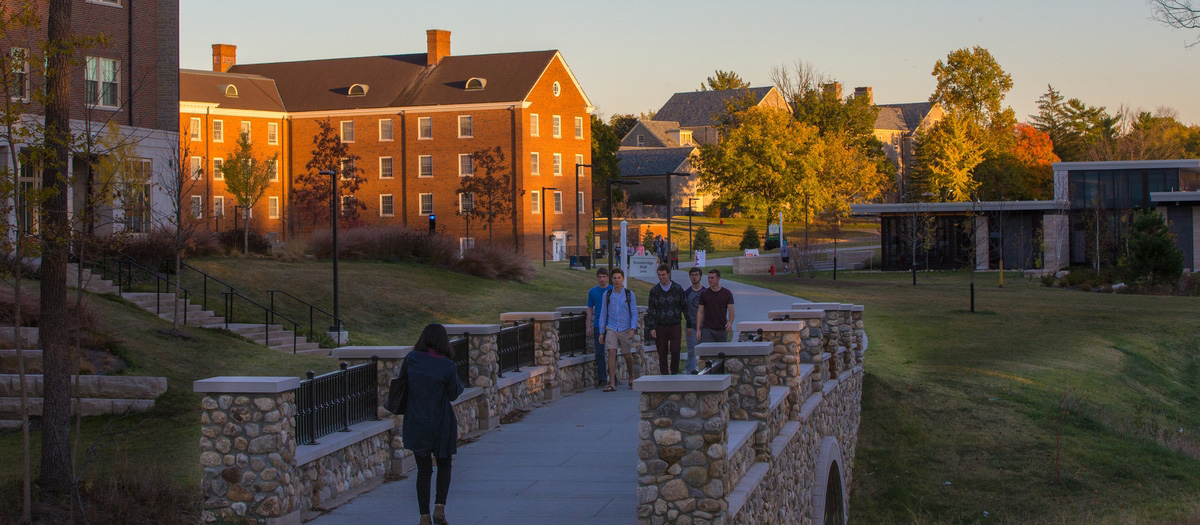 Students walking across a stone bridge on Western Campus. 
