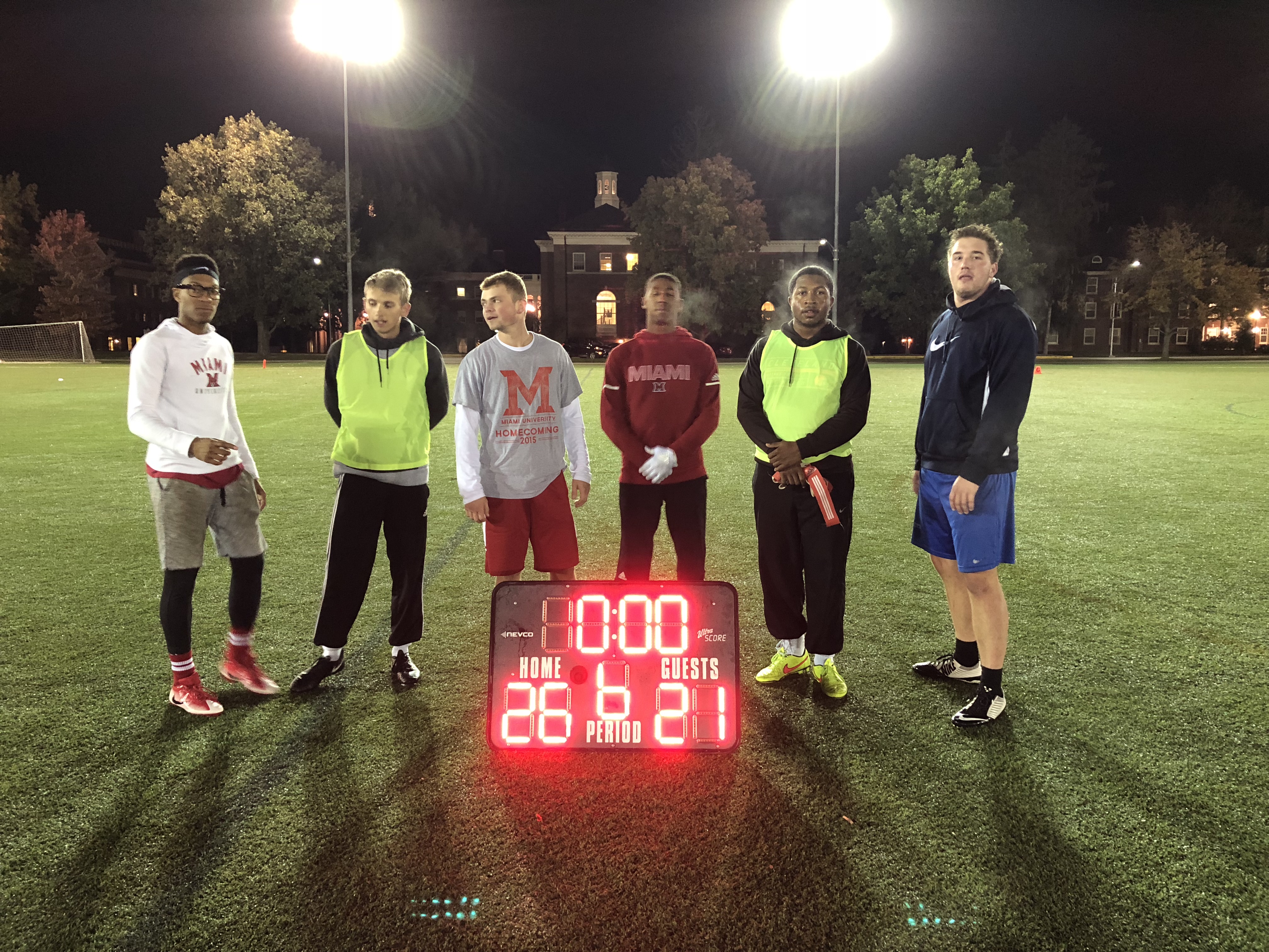 Flag football runner up team for Fall 2018 poses with final game scoreboard.