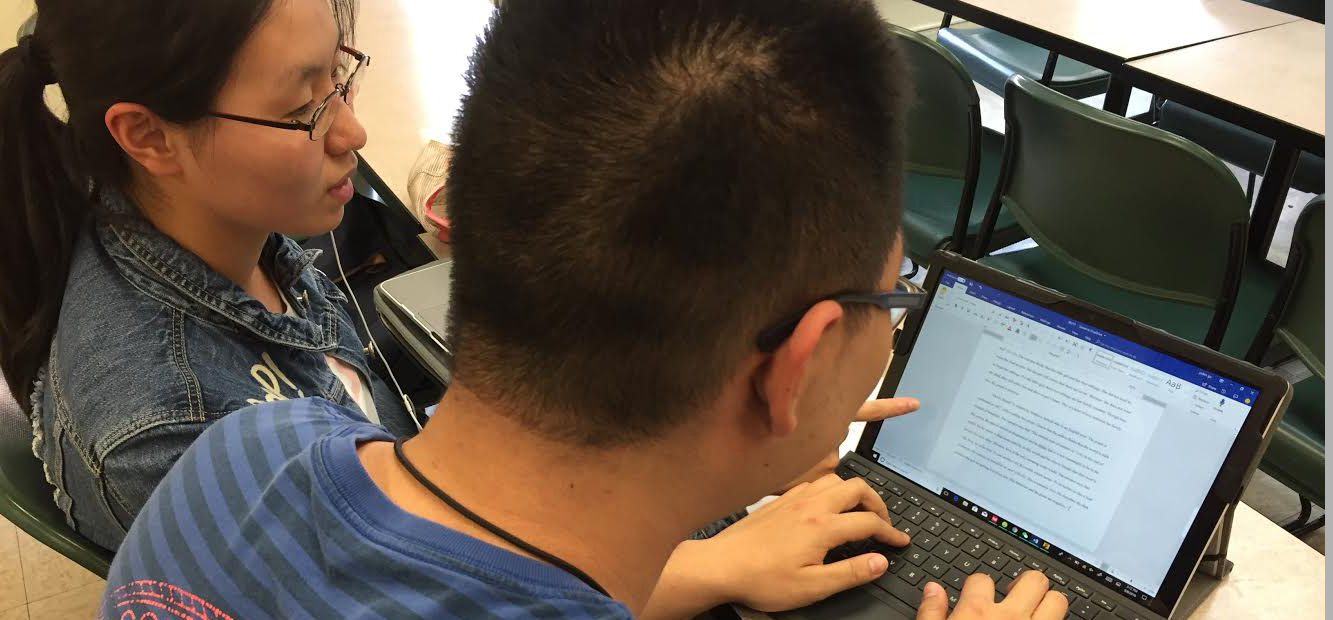  Two students working together with a laptop