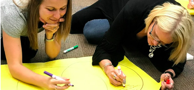 Two teachers working on a poster 