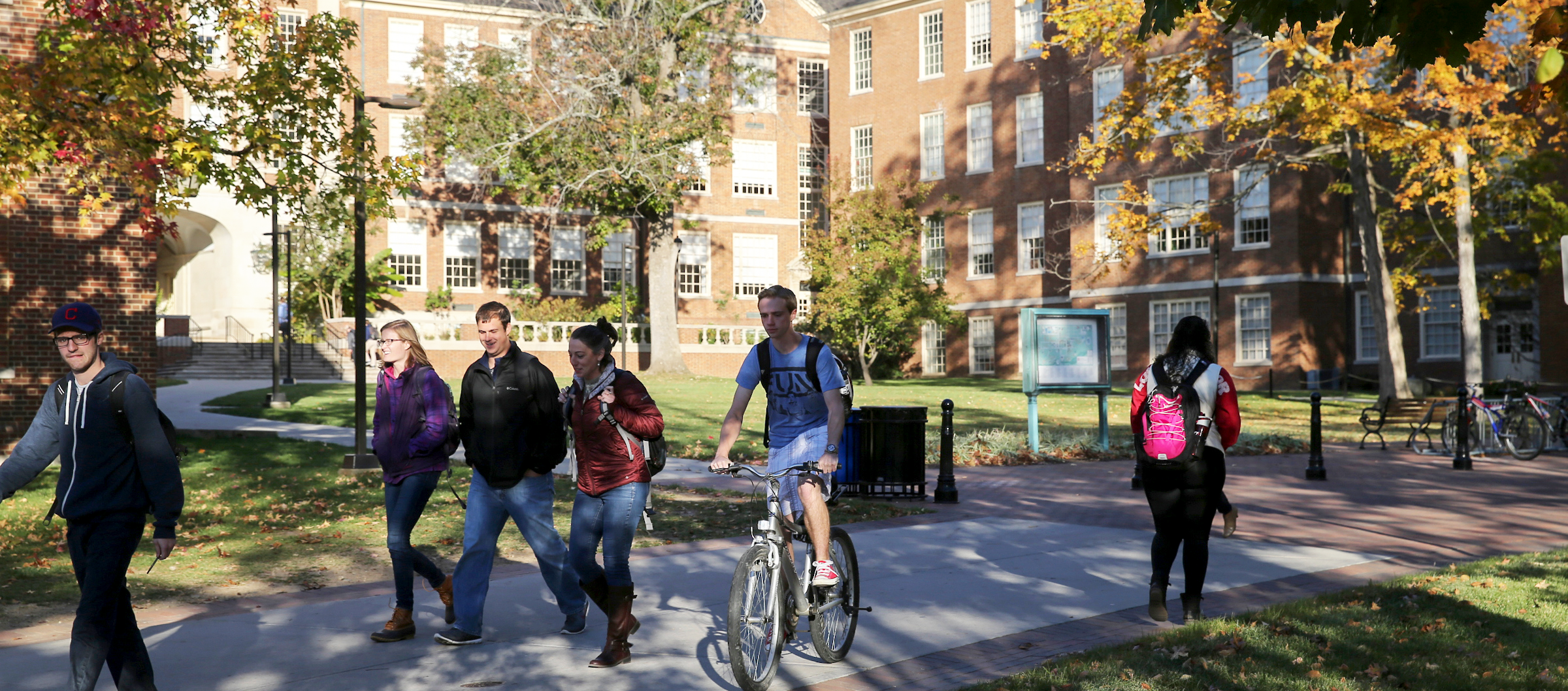 Students walk and ride bikes near Upham Hall