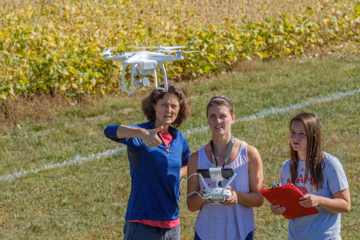 students and faculty member operating a drone