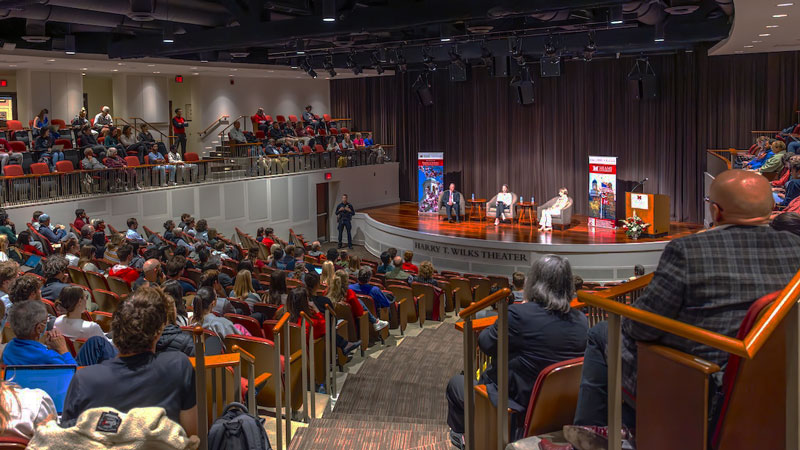 The Janus Forum audience inside Armstrong Student Center's Wilks Theater listens attentively to the two speakers.